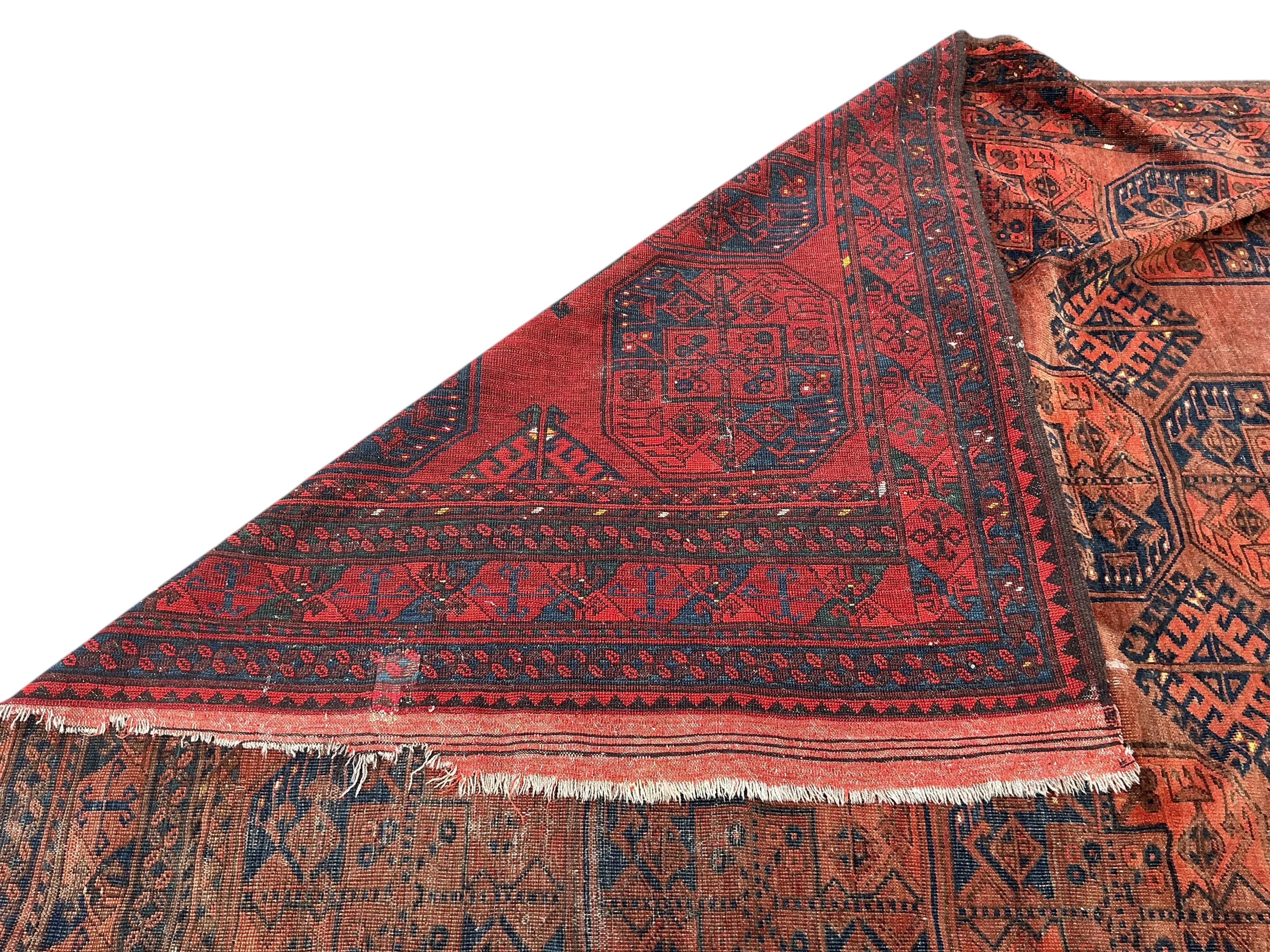 An Afghan brick red ground carpet, 285 x 210cm